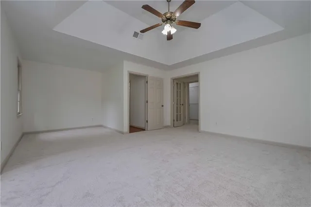 an empty room with a ceiling fan and a fan