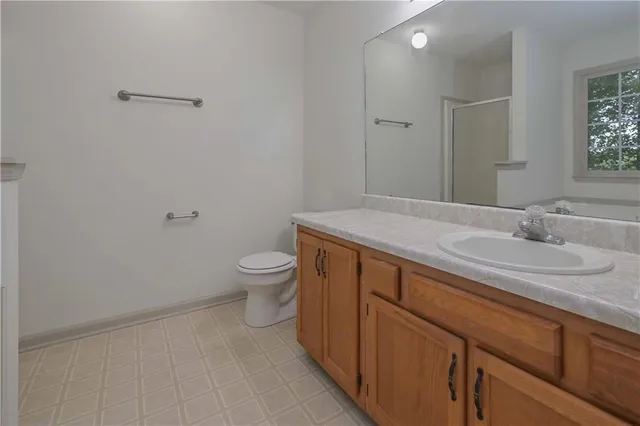 a spacious bathroom with a granite countertop sink a toilet and a mirror
