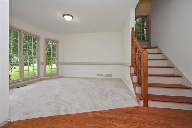 a view of a big room with wooden floor and stairs