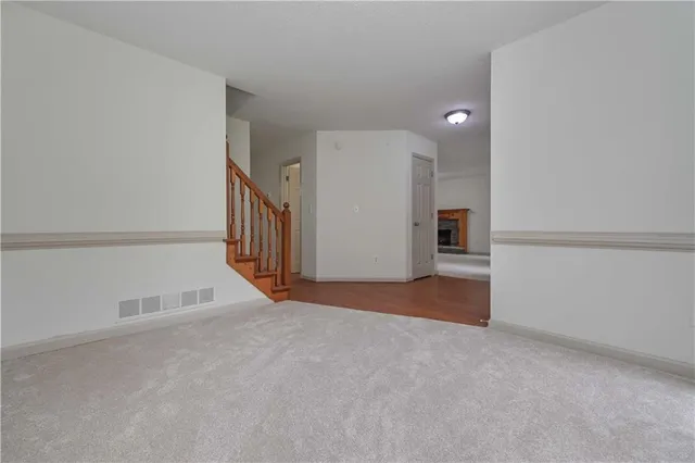 a view of an empty room with closet and windows