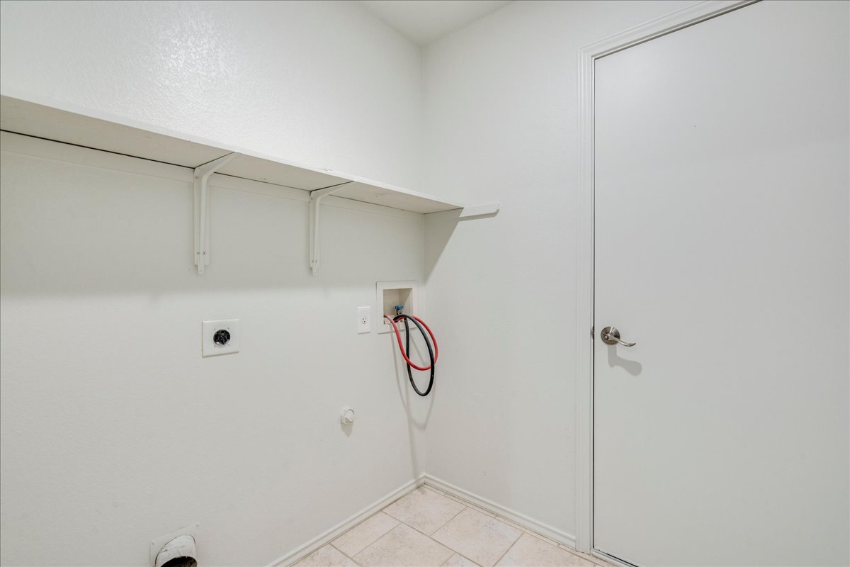 100 Easy Street Hutto, TX 78634 - Photo 25 of 36 Functional laundry space with integrated shelving and tiled flooring provides everyday convenience.