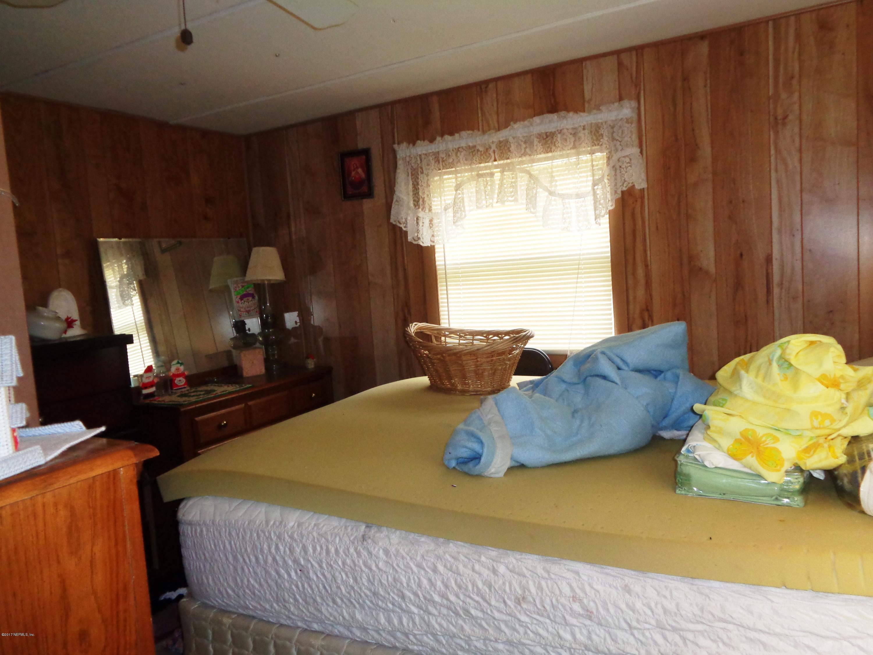 137 Istanbul Street Interlachen, FL 32148 - Photo 7 of 18 a bed sitting in a bedroom next to a window