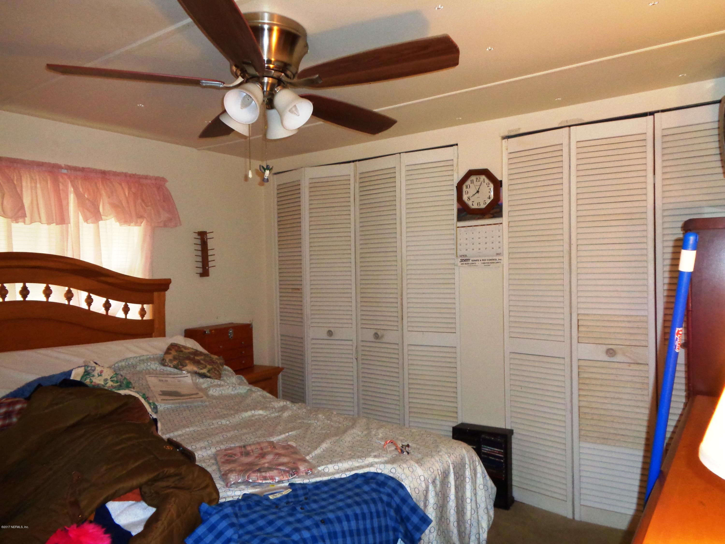 137 Istanbul Street Interlachen, FL 32148 - Photo 9 of 18 a bedroom with a bed and a chandelier