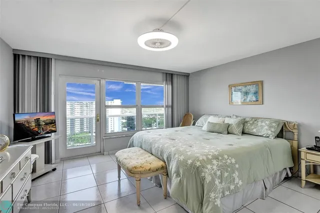 a bedroom with a bed and a large window