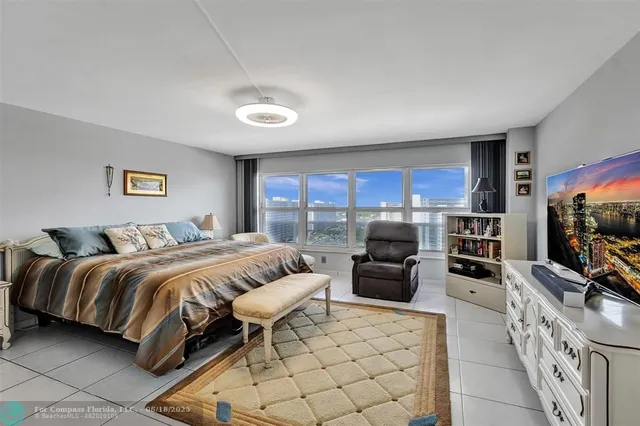 a spacious bedroom with a bed and a flat screen television