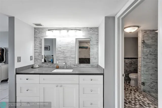 a bathroom with a granite countertop sink and a mirror