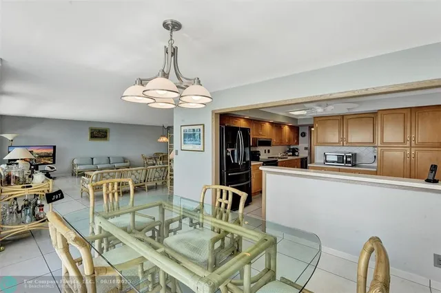 a kitchen with stainless steel appliances granite countertop a stove top oven a sink dishwasher a dining table and chairs with wooden floor