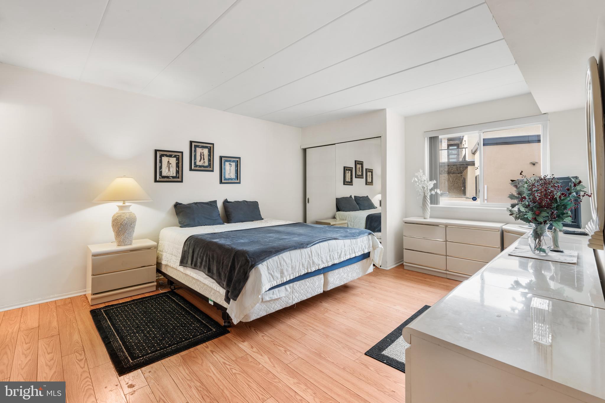 9945 Norwalk Road, Unit 15A Philadelphia, PA 19115 - Photo 12 of 23 a bedroom with a bed lamp and a fireplace