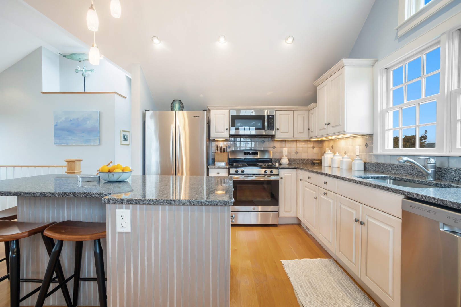 5 Tautemo Way Nantucket, MA 02554 - Photo 9 of 30 a kitchen with granite countertop a refrigerator oven a sink dishwasher and white cabinets with wooden floor