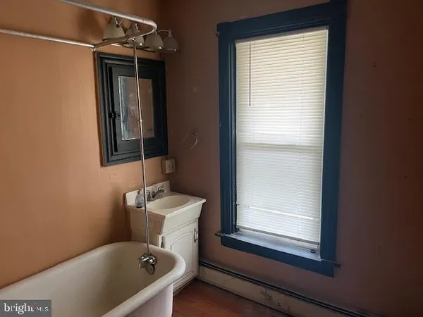 a bathroom with a tub sink and mirror