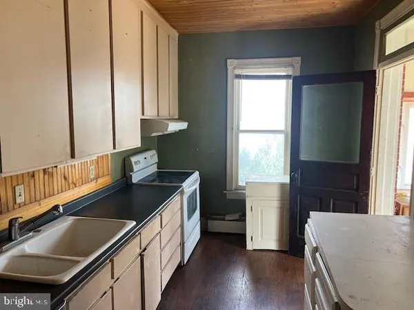 a kitchen with granite countertop a sink stove and cabinets