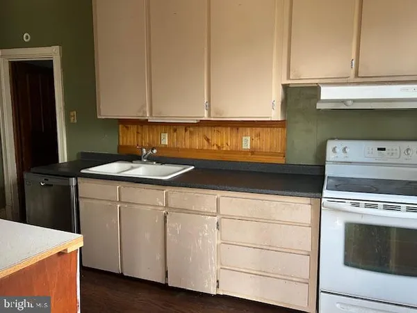 a kitchen with granite countertop white cabinets and white appliances