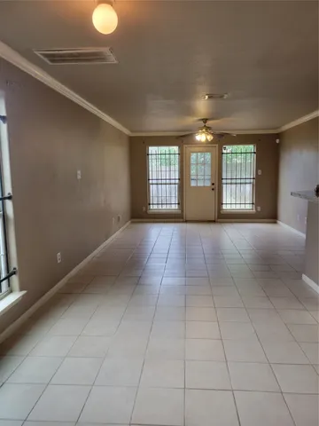 a view of an empty room with a fireplace and windows
