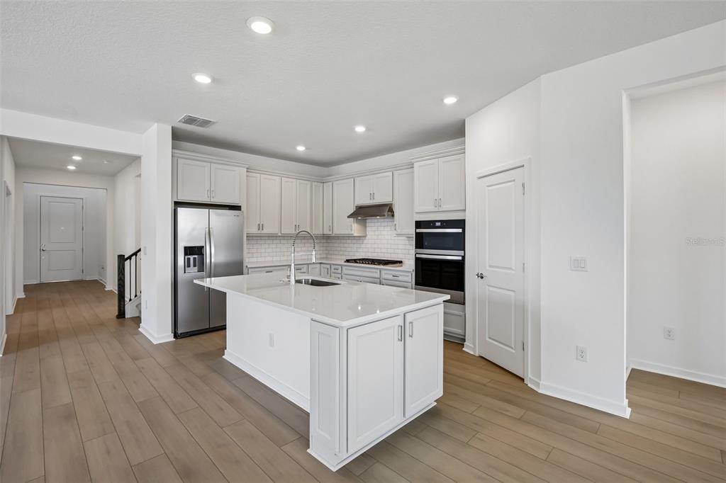 9932 Redwood Rdg Avenue Riverview, FL 33578 - Photo 4 of 38 a kitchen with refrigerator a sink and wooden floor