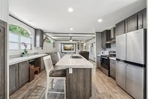a kitchen with kitchen island a stove a sink and a refrigerator