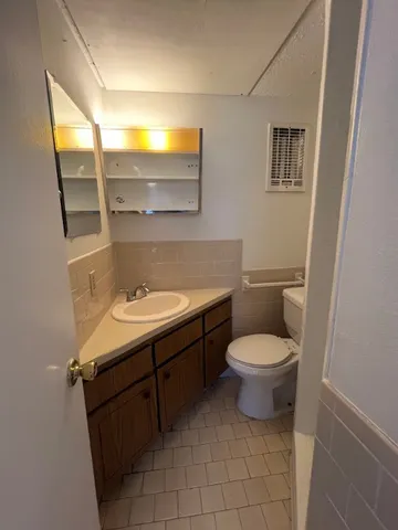 a bathroom with a toilet a sink and mirror