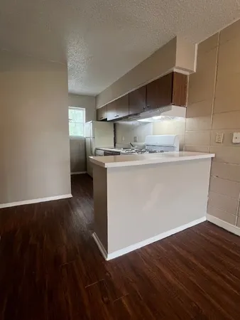 a kitchen with granite countertop a stove and wooden floor