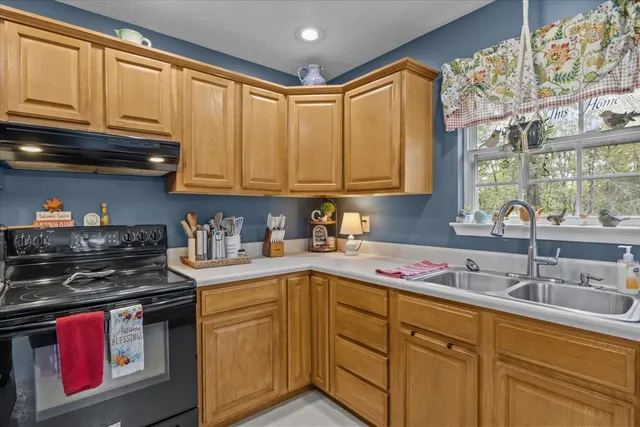a kitchen with stainless steel appliances granite countertop a sink stove and cabinets
