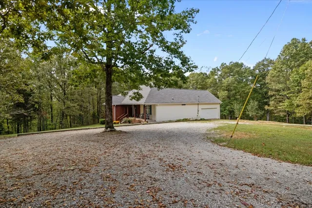 a view of a house with backyard and trees