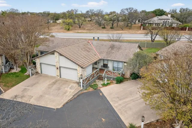 a view of a house with a yard and a large tree
