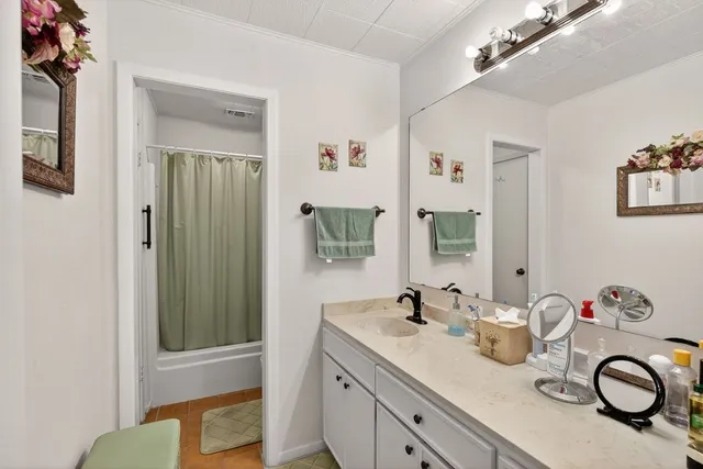 a bathroom with a granite countertop sink and a mirror