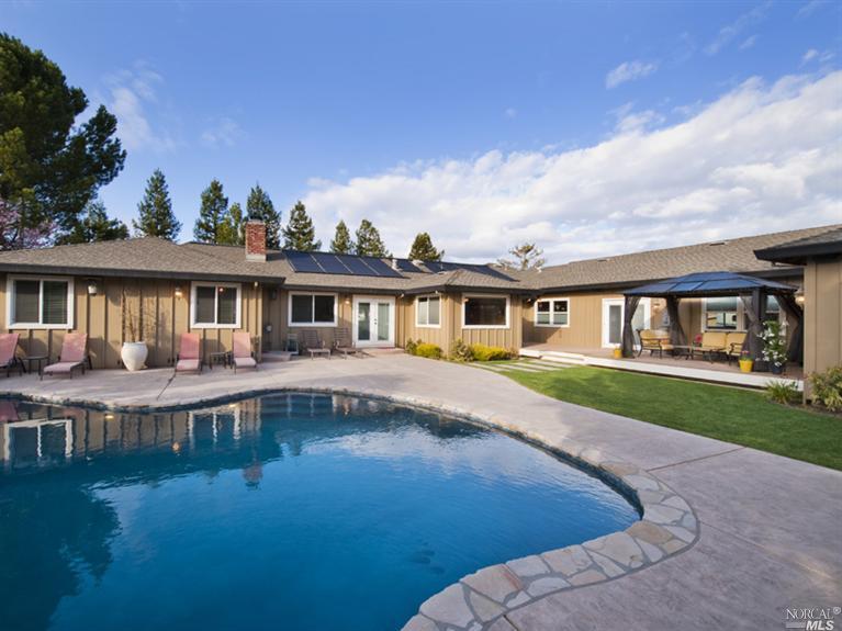 a front view of a house with yard patio and lake view