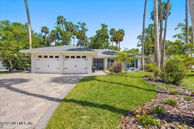 a front view of a house with a yard and trees