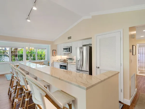 a kitchen with stainless steel appliances a microwave a stove and white cabinets