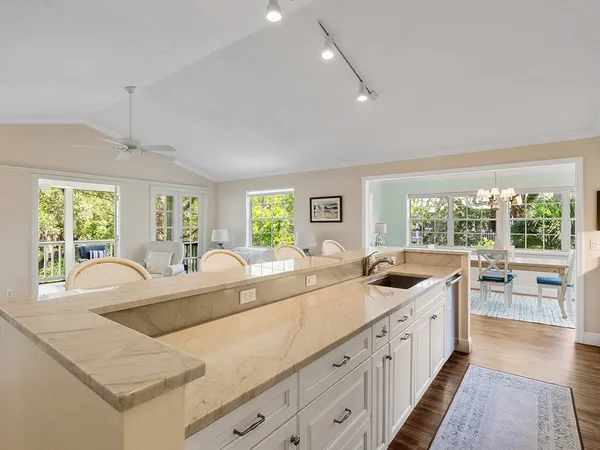 a living room with stainless steel appliances kitchen island granite countertop furniture and a large window