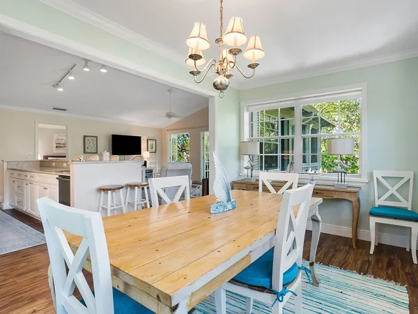a view of a dining room with furniture a chandelier and wooden floor