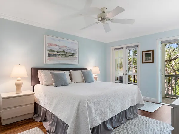 a bedroom with a large bed and a chandelier