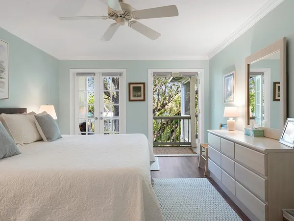 a bedroom with a balcony a large bed and a window