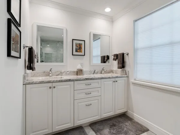 a bathroom with double sink and a mirror