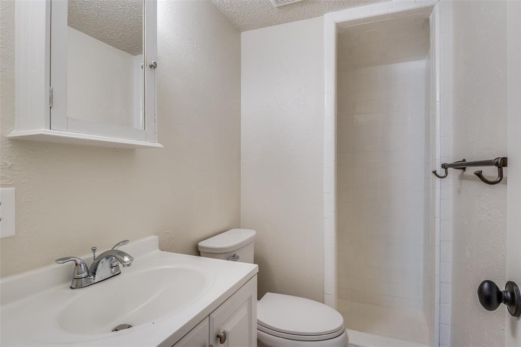 11348 McCree Road Dallas, TX 75238 - Photo 7 of 15 a bathroom with a sink a toilet and shower