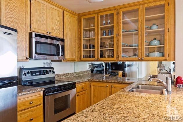 2901 Peninsula Road, Unit 150 Oxnard, CA 93035 - Photo 10 of 24 a kitchen with stainless steel appliances granite countertop a stove a sink and a microwave