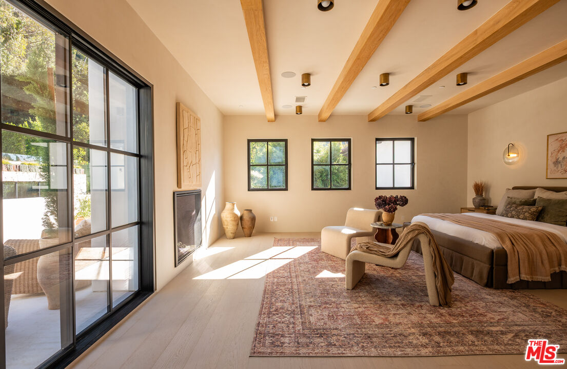 966 Stone Canyon Road Los Angeles, CA 90077 - Photo 11 of 30 a bedroom with a bed and wooden floor