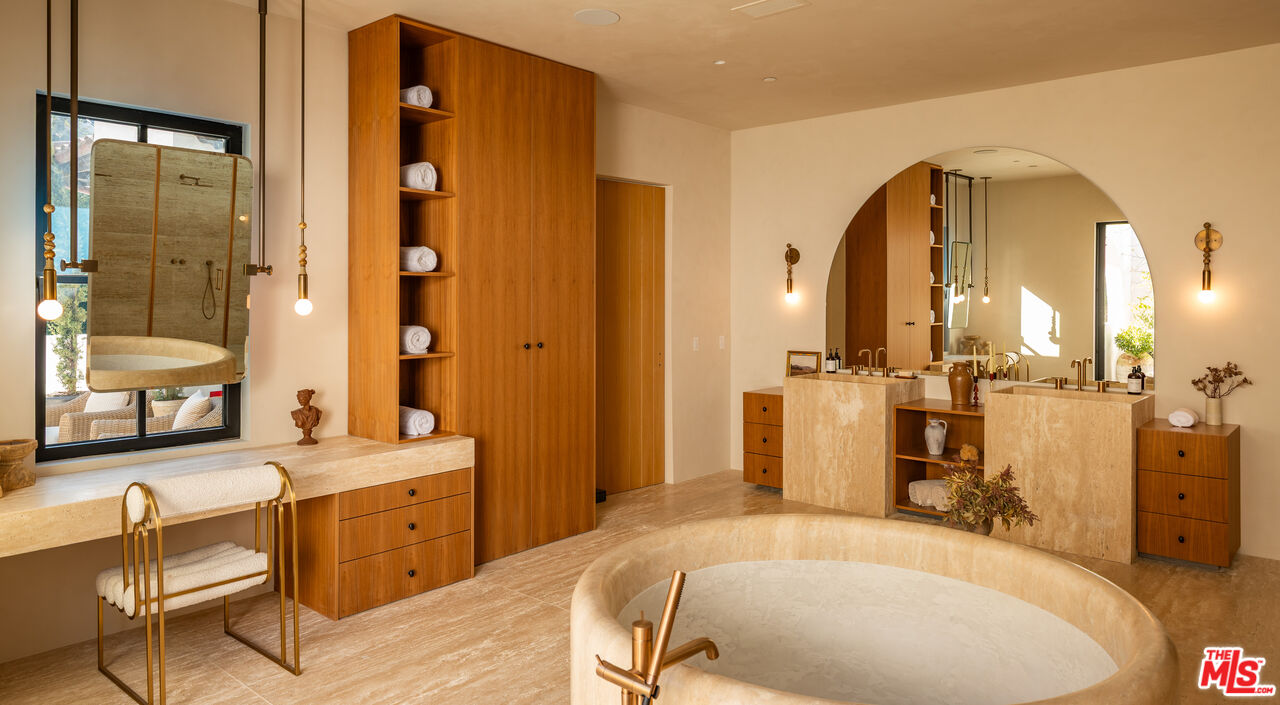 966 Stone Canyon Road Los Angeles, CA 90077 - Photo 15 of 30 a bathroom with a tub a sink and a mirror