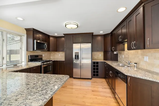 a kitchen with stainless steel appliances granite countertop refrigerator stove microwave and sink