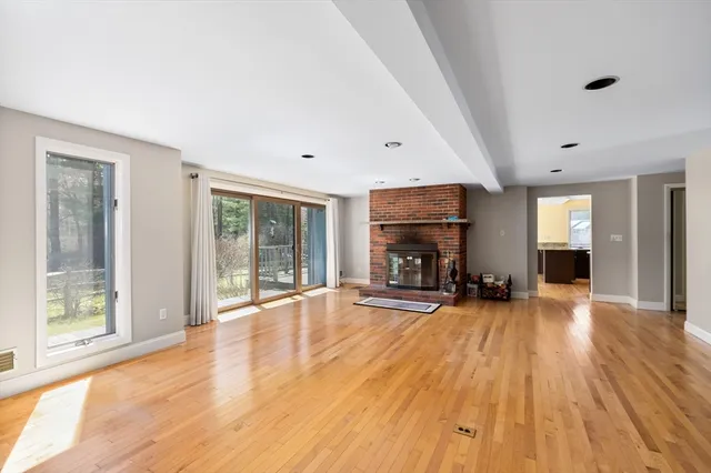 a view of a livingroom with wooden floor and a fireplace