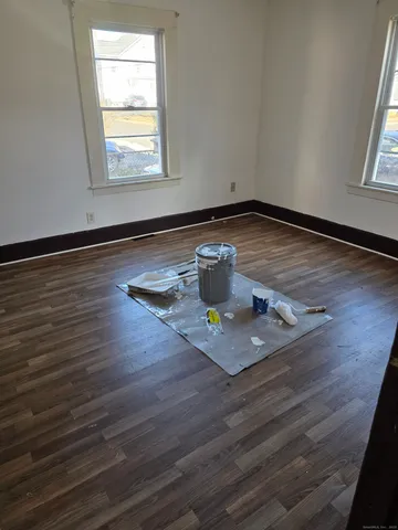 a view of empty room with wooden floor and window