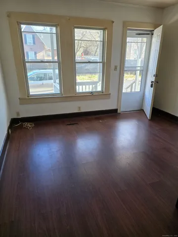 a view of room with wooden floor and windows