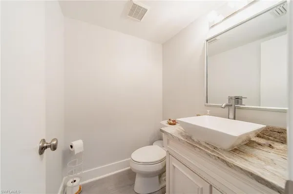 a bathroom with a granite countertop toilet and a sink