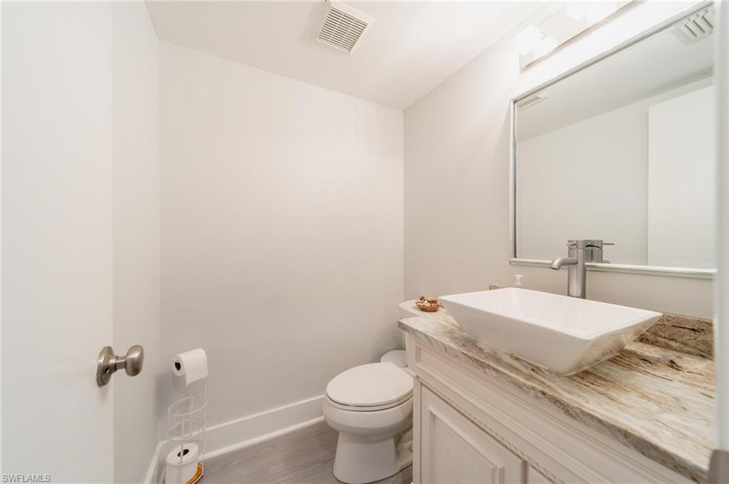 820 Meadowland Drive, Unit D Naples, FL 34108 - Photo 15 of 30 a bathroom with a granite countertop toilet and a sink