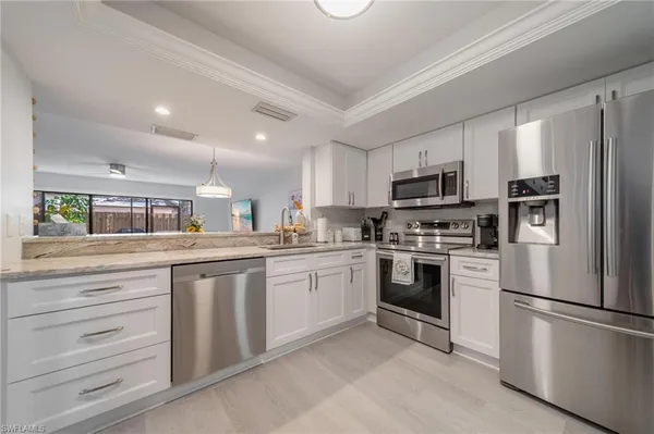 a kitchen with granite countertop white stainless steel appliances and refrigerator