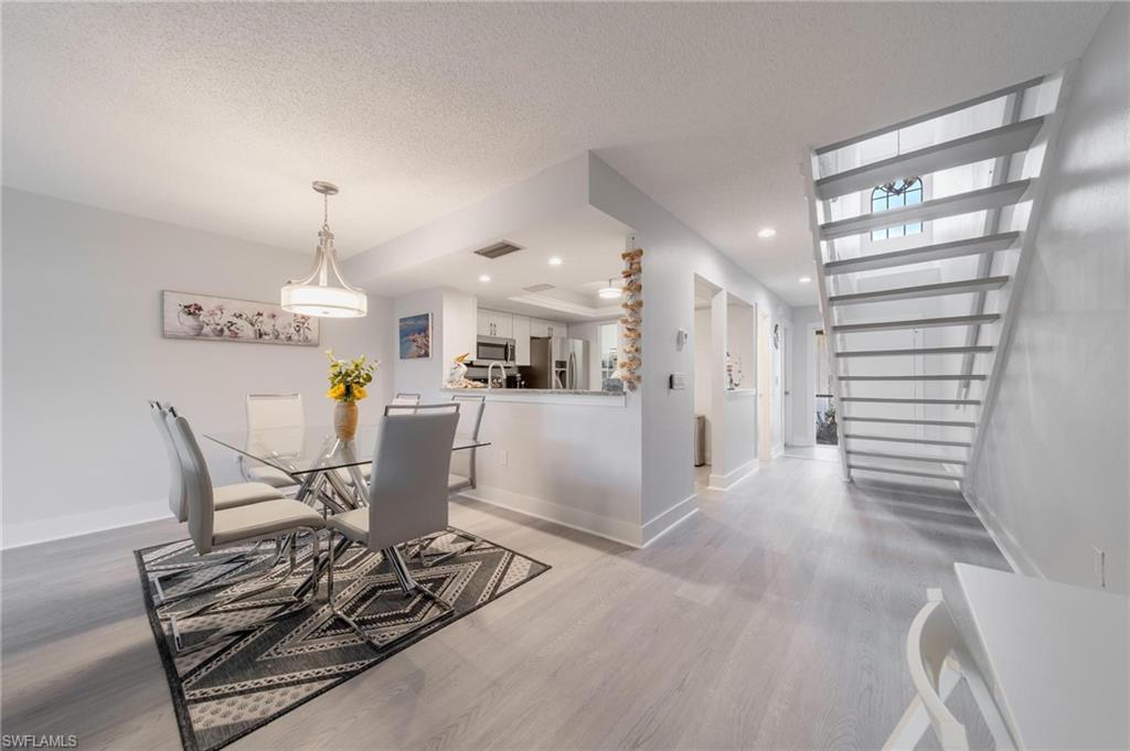 820 Meadowland Drive, Unit D Naples, FL 34108 - Photo 19 of 30 a dining room filled with furniture and a chandelier