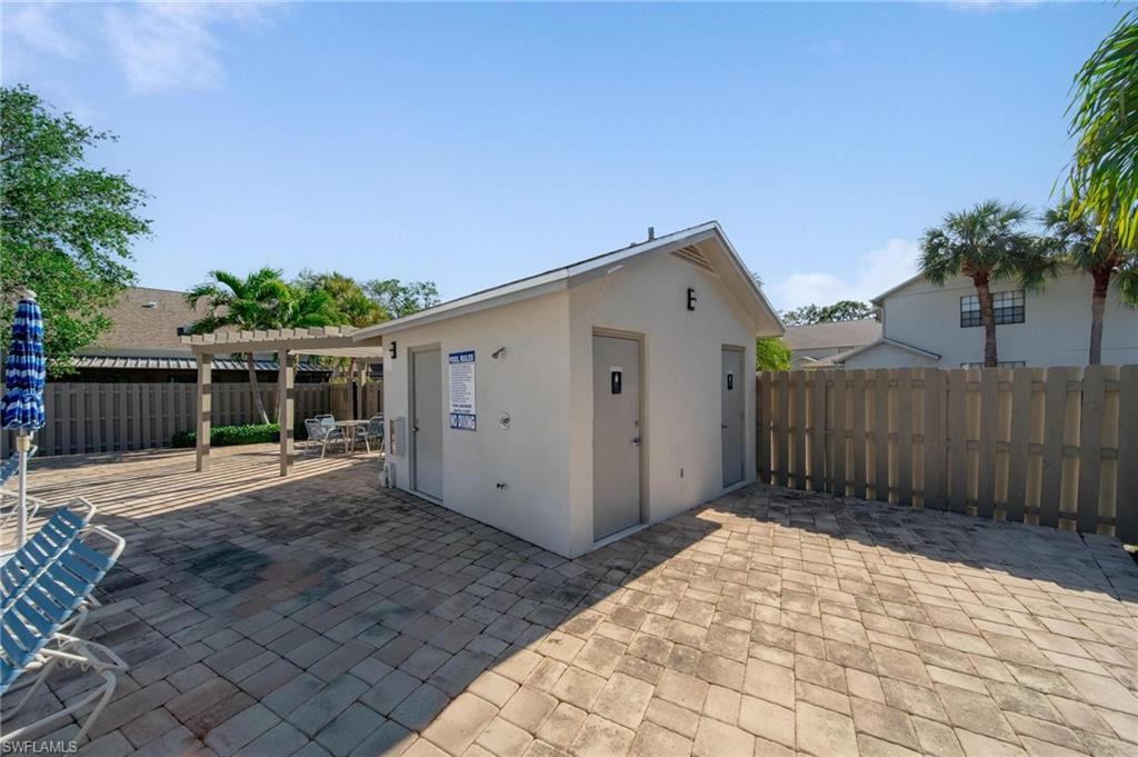 820 Meadowland Drive, Unit D Naples, FL 34108 - Photo 28 of 30 a view of a house with a small yard and wooden fence