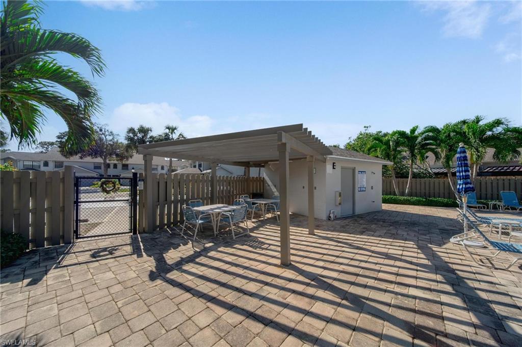 820 Meadowland Drive, Unit D Naples, FL 34108 - Photo 29 of 30 a view of a chair and tables in patio of the house
