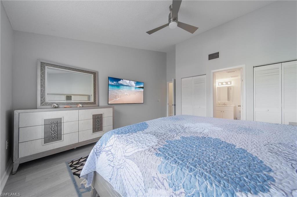 820 Meadowland Drive, Unit D Naples, FL 34108 - Photo 10 of 30 a bedroom with a bed and a chandelier