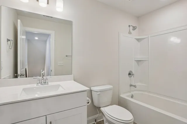 a bathroom with a sink toilet vanity and shower