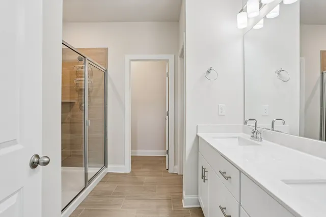 a bathroom with a double vanity sink a mirror and a shower